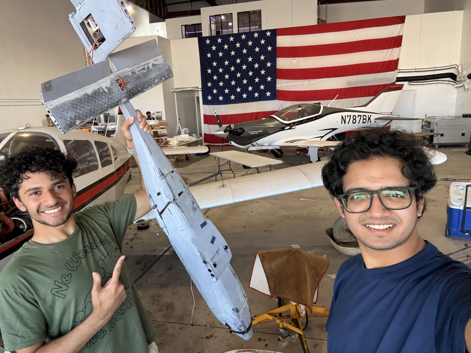 Kush Agarwal and Arvin Singh in the hangar, holding up the demonstrator